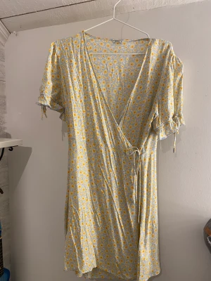 Blommig klänning - Blommig omlottklänning från asos storlek M-XL beroende på hur man vill ha passformen Bra skick
