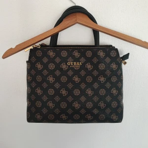 Guess Turin Satchel - Väska från Guess, 32×23 cm. Medföljer avtagbar axelrem och dustbag. Fint skick men pyttelite slitage på undersidan som ej syns.  Slutsåld och kostade 1495 kr🌷