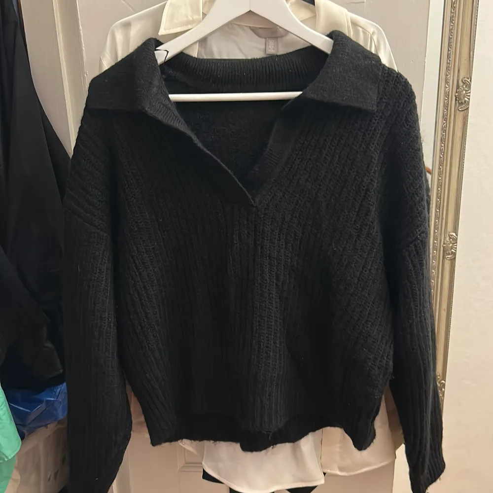 En svart stickad tröja med krage ifrån ginatricot, i bra skick, använd 2 gånger. Storlek L men kort i längden. Stickat.