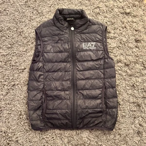 Ea7 väst  - Jag säljer min ea7 väst som jag inte använder längre den är storlek s men skulle nog passa på någon som bär M jag är 186 (ni ser på andra bilden hur den sitter på mig) Det med följer en liten påse som västen får plats i.