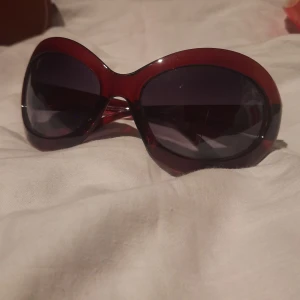 Solglasögon  - Mörkröd/ bruna glasögon. Har tyvärr en liten repa i glaset men inget som stör. Inte använda för jag tycker jag ser ut som ett bi, referens bild nr 3
