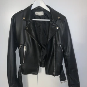 Svart skinnjacka - Säljer min svarta skinnjacka (fuskläder) i storlek 34. Aldrig använd. 