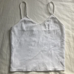 Vitt linne - Säljer ett vitt ribbat linne som är jättefint till sommaren. Inga tydliga tecken på användning. För fler bilder, kom privat. Säljer pga att jag aldrig använder det, passar xxs/xs❤️