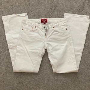 Lågmidjade jeans - Ett par vita lågmidjade jeans med orangea detaljer, som sorligt nog inte passar mig:( Inga tydliga defekter.