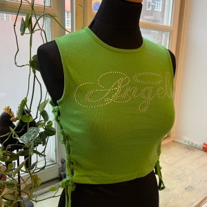 Limegrönt knyt-linne med rinestones - Linne från Urban outfitters med rinestones-tryck i nyskick! Dockan på bilden är en strl S. 