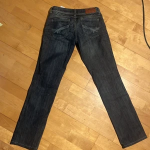 Tommy Hilfiger jeans - Säljer dessa jättefina lågmidjade jeans från Tommy Hilfiger pågrund av att dom är för små! Dom är raka i benen &har snygga bakfickor, har inga defekter och är i väldigt bra skick. Innerbenslängd: ca 77 cm. Midja: ca 40 cm (rakt över). Skriv vid intresse!!