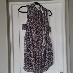 Festklänning  - Oanvänd festklänning med glitter och pärlor. Klänningen är luftig och öppen på sidorna.