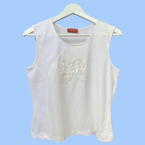 Vitt linne med paljetter - Snyggt vintage linne med paljetter och pärlor. Tyget är bomull och mycket stretchigt. 41 cm bred och 52 cm lång, bra skick. Hör gärna av dig med frågor eller om du vill se fler bilder:)