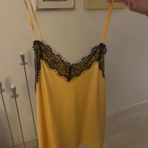 Linne - Gult linne med svart spets i strl S/M och används fåtal gånger. Säljer för 65kr