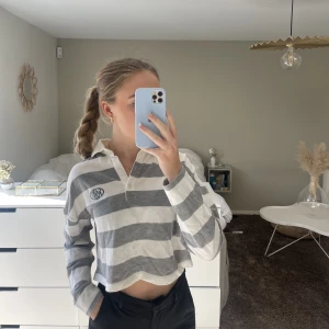 Randig tröja med krage  - Långärmad randig tröja med ett litet grönt tryck och en krage med knappar. Aldrig använd! Köparen står för frakten:)