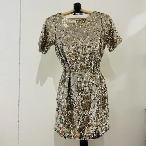 Bik Bok Klänning  - Nyskick!! Glittrig guld klänning som passar perfekt till fester. Har endast använt en gång på nyår. Skärp medföljer inte.