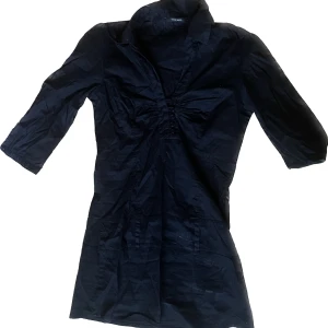 Svart topp - En lite längre svart topp med knappar och rysch i fram, köpt secondhand men märket är Vero Moda, strl XS🖤 Säljes då den tyvärr inte kommer till användning längre. Köparen står för frakten, kan även mötas upp i Stockholm🖤