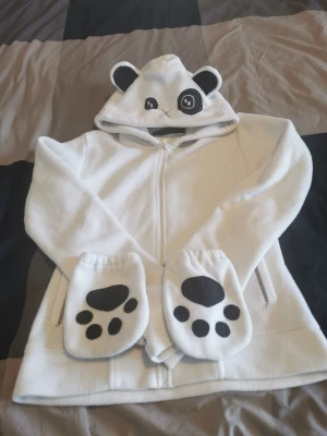 Fleecetröja - Supermysig panda/björn tröja i fleece, knappt använd. Vantar med texten love och hate ingår. Möts upp på nedanstående platser eller skickas. 