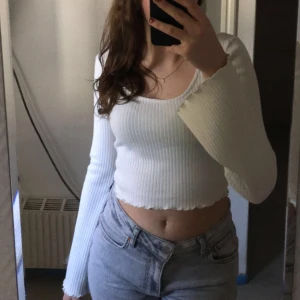 Stickad vit topp Gina tricot - Säljer en stickad vit topp med utsvängda armar från Gina tricot i storlek S