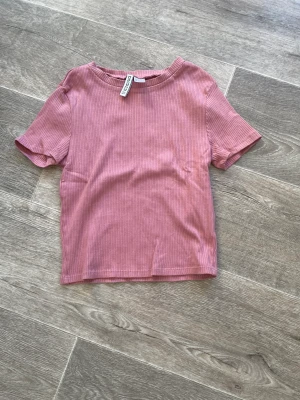 Croppad T-Shirt HM - Rosa croppad t-Shirt från hm. Oanvänd i nyskick.