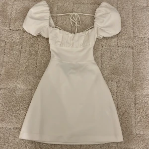 Vit Zara Klänning  - Super fin vit sommar klänning från Zara med band som korsar i ryggen, aldrig använd🤍✨