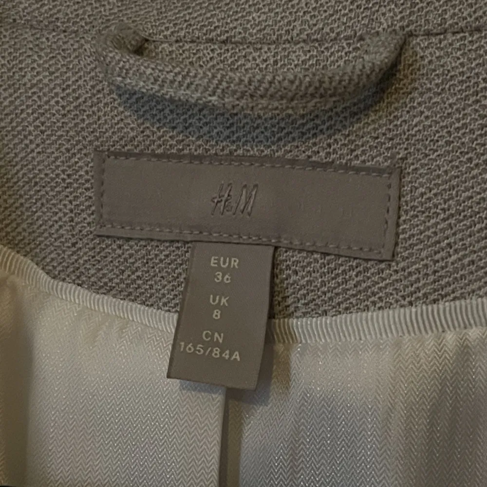 En ljusgrå/beige figursydd kavaj i storlek 36 från H&M. Aldrig använd = nyskick. Köparen står för frakt.. Kostymer.