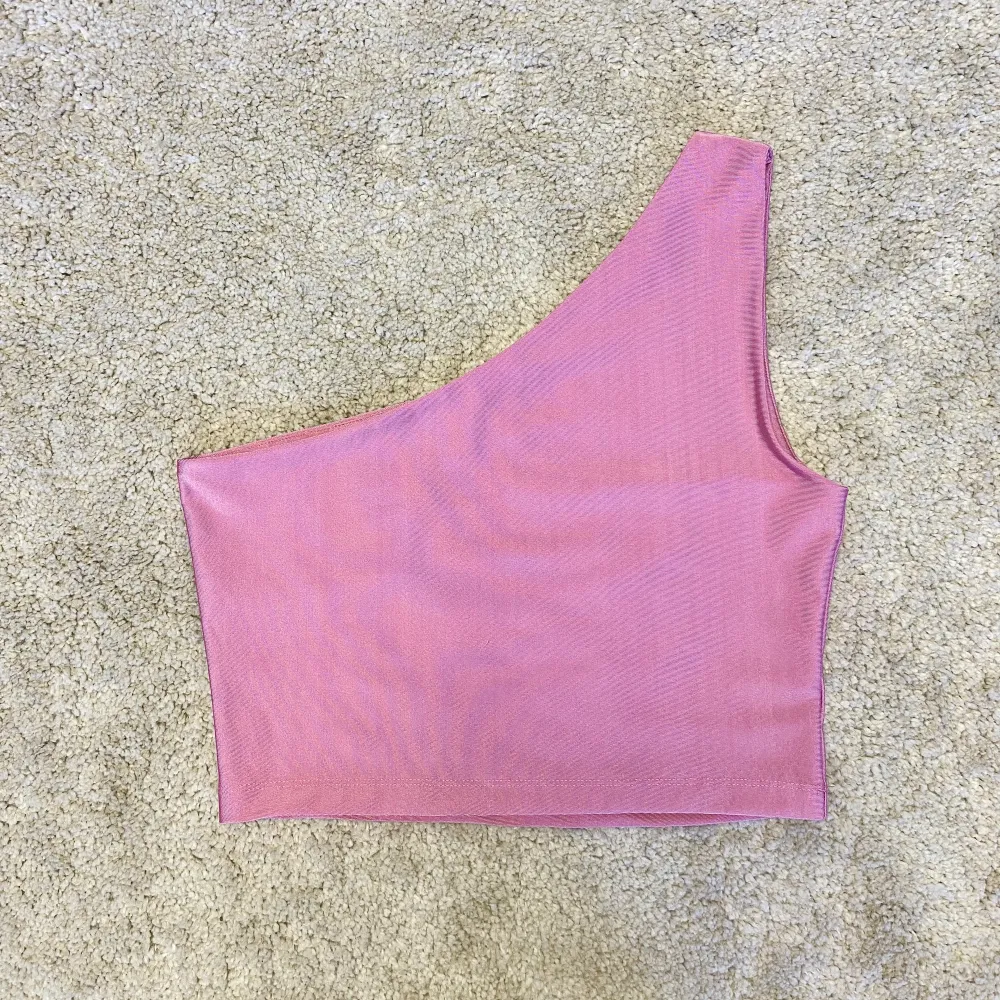 Fräck one shoulder topp i en snygg rosa färg från BikBok. Storlek M. Endast använd en gång så den är i mycket fint skick! Gjord av stretchigt material så den är väldigt skön att ha på sig. Perfekt till en snygg kjol för för en härlig utekväll 🌸✨💕. Toppar.