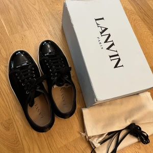 Lanvin skor - Säljer nu mina fina lanvin dbb1 i svart mocka samt vit sula med cap toe. Grymt skick, använda 4 gånger med en flaw som visas på sista bilden. Påverkar ej priset då det ej är märkbart och klassas som general wear. Storlek 9 (43/44). BIN 2699, bud 2299.