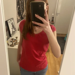 Röd t-shirt - Snygg kortärmad tröja, v uringad så passar bra med halsband, använd men inga fläckar m.m