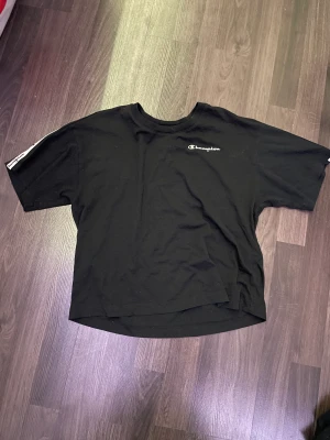 Champion t-shirt - Jag säljer en champion t-shirt i strl S som är lite croppad med vita band på axlarna för 150kr+frakt💕 Säljer pågrund av att den bara tar plats i garderoben