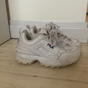 Fila sneakers i storlek 38 - Vita sneakers från Fila i storlek 38. Skorna är använda och har lite slitningar på insidan av hälen men är i övrigt i gott skick. 