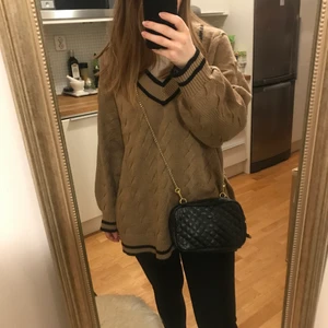 Svart axelväska med gulddetaljer - Svart liten väska från ginatricot med läderimitation, guldig avtagbar kedja samt litet innerfack inuti. Fick som present runt 2012 och använde den flitigt och är därför lite nött i ena hörnet, men annars i väldigt bra skick.