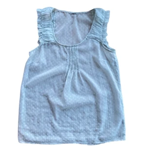 GENOMSKINLIG TOPP  - Genomskinlig ljusblå topp med prickigt mönster. 