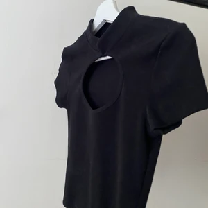 Topp - Cool top med öppet bröst, som man kan knäppa vid halsen med knapp och ögla, använd 1gång i så nyskick 