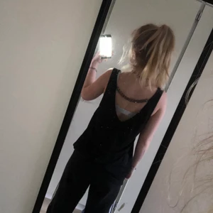 Svart linne med kedja bak - Jätte fint svart linne med en kedja hängandes bak. Använd några gånger men inget som syns. 