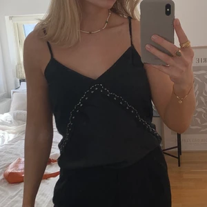 Snygg svart topp - Jättesnygg svart topp med silvriga detaljer! Storlek l men skulle mer säga att den är i storlek m (den har även justerbara band) 🫶🏼✨ Kan skicka men köparen står för frakten :)