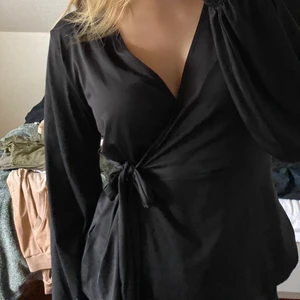 Blus - Svart bluse som är omlott med knyttning vid midjan. Tröjan är i storlek M. Passar storlek S men den är lite luftig då. Köparen står för frakten. Skriv för fler frågor🤍🤍