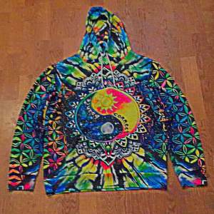 En hoodie med jing & jang tecknet på både fram och baksidan. Den har mycket färger och mönster
