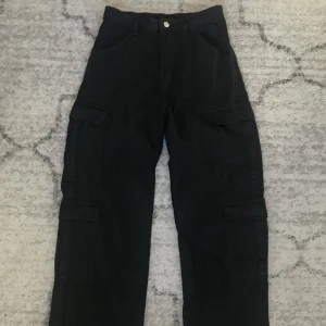 Cargojeans - svart - Dessa jeans är i storlek M och har två cargofickor på båda benen. Jag är 174 och de är lite långa på mig men de går att vikas upp. Har knappt använt dem.
