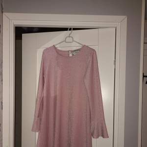 En rosa glittrande klänning med utsvängda armar från GEKÅS/ullared i strl 170 men passar XS-M. Den har silvriga trådar insydda som gör den glittrande. Perfekt till en finare middag med familj/vänner eller en utkväll.