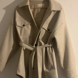 Beige kappa - Beige kappa i storlek 36 Från Nelly. använd få gånger och i gott skick.