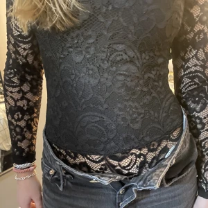 Spetsbody - Helt oanvänd spetsbody. String baktill och insydda ilägg vid bysten