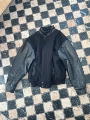 Vintage varsity jacket - En helsvart varsity jacket köpt på Beyond Retro i Göteborg. Jackan är i bra skick med inga tydliga defekter, men lite sliten tack vare att den är använd en del. Jackan har storlek XL och sitter som en XL. Skriv gärna ifall du har några frågor :)