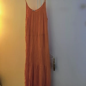 Ellos klänning - Stl 42-44. Aldrig använd. Orangeröd ungefär, mer åt orangea hållet. 