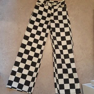 Schack Rutiga Utsvängda Jeans - Ett par schack rutiga utsvängda jeans från Monki i storlek 26. I väldigt gott skick då dem aldrig är använda. Säljer för 250 kr + frakt. Skriv om ni har några frågor.