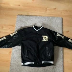 Varsity/college jacka, strorlek M/S - Varsity/college jacka, strorlek L men den passar som M/S. Den är i nyskick då jag inte använt den eftersom den inte passar mig som är 190 cm. Skön jacka till sommaren.