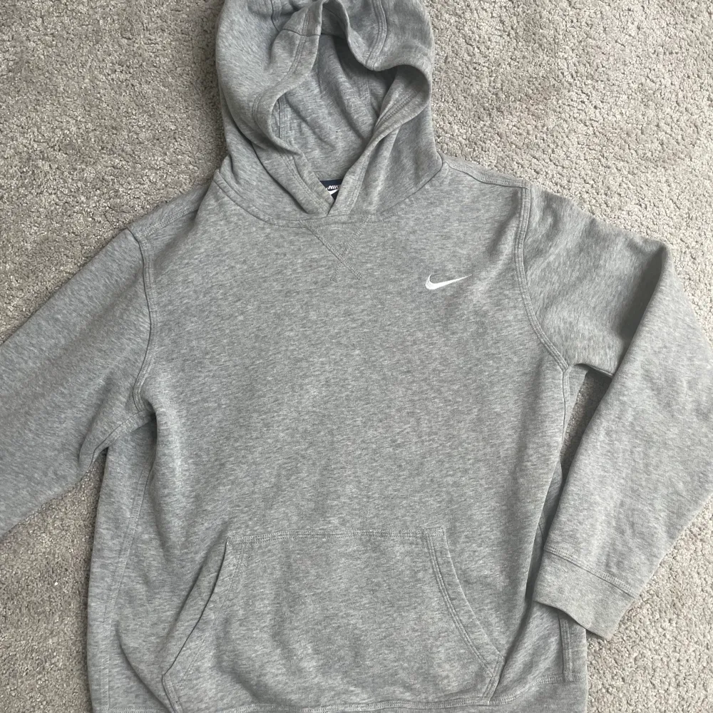 En grå Nike-hoodie i bra skick. Storlek M. Köparen står för frakt . Hoodies.
