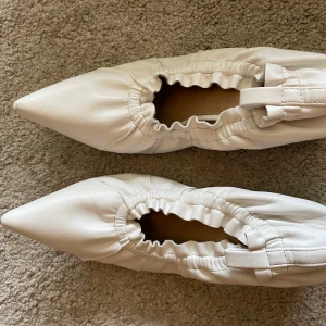 Klackar NAKD - Vita klackar med resår från Nakd. Skavank på ena klacken, därav priset. Storlek 38.