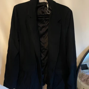 Blazer - Svart blazerfrån Nelly. Blivit skrynklig efter tvätt.