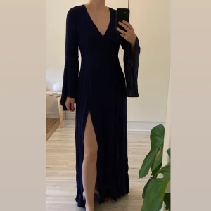 Marinblå klänning strl XS - Mjuk och flowy klänning med dubbel-slits i en mörkare marinblå ton. Aldrig använd pga fel storlek. UK size 8/XS. 