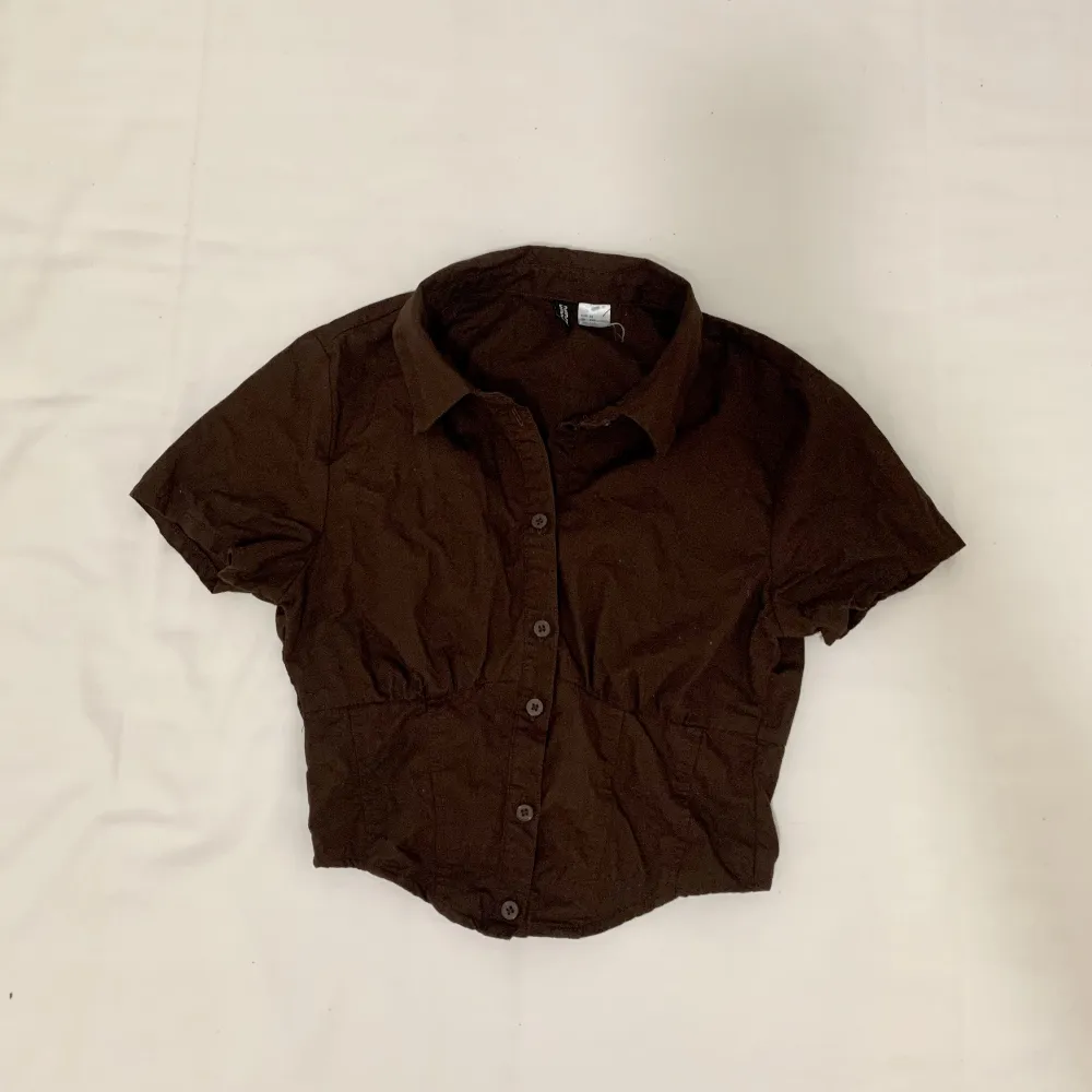 Brown button-up shirt from H&M. Tight fit and cropped. Size XXS but can fit XS. Worn once!. T-shirts.