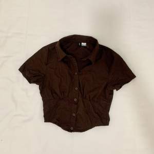 Brown button-up shirt from H&M. Tight fit and cropped. Size XXS but can fit XS. Worn once!