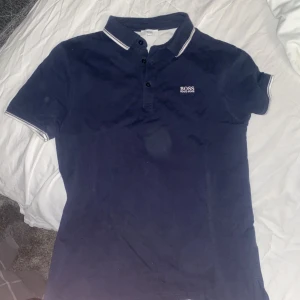 Hugo boss piké  - Säljer min boss piké då den blivit för liten. Den har inga fläckar eller liknande utan det är kameran som fått det att se ut så. Gott skick storlek S
