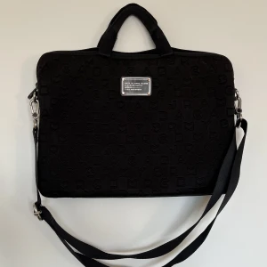 Marc Jacob datorväska - Super fin och stor datorväska från Marc Jacobs som jag köpte begagnad men som är för stor för min dator. Dragkedjorna var trasiga vid köp men går lätt av fixa själv eller hos ett skrädderi. Har ett stort fack för datorn och ett mindre fack på baksidan.