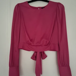 Rosa satintopp - Rosa satintopp med justerbar rosett och öppen rygg, från Vero Moda. Aldrig använd så prislapp är kvar. Nypris 379.95. Funkar till er med storlek M/L i vanliga fall.